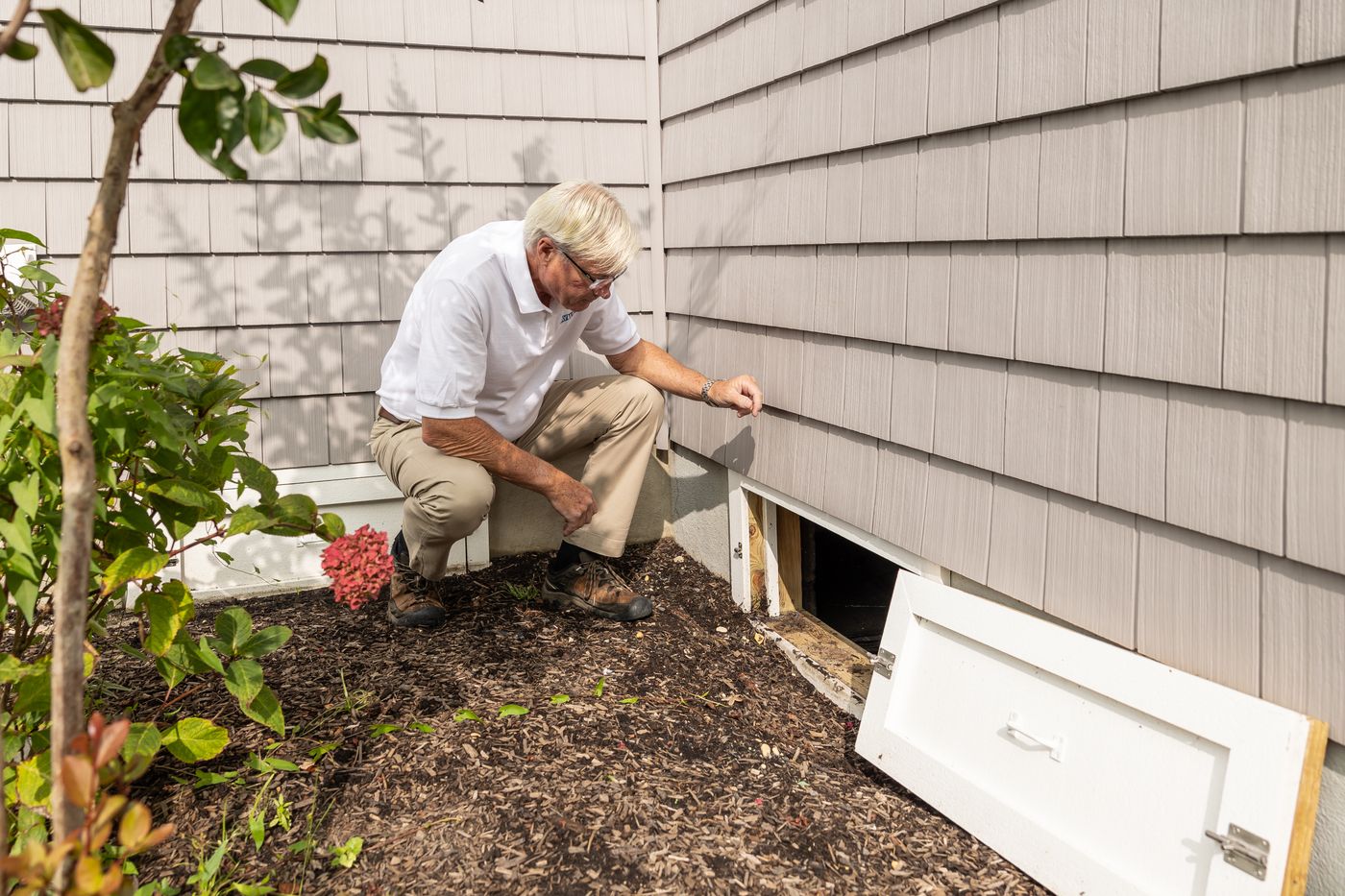 Inspector at the entrance to a home's crawl space